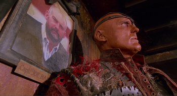 Movie still from “Waterworld” (1995), directed by Kevin Reynolds – A statue and a picture of a man; Close Up shot, Low angle