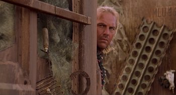 Movie still from “Waterworld” (1995), directed by Kevin Reynolds – A person leaning against a wall; Close Up shot, Low angle