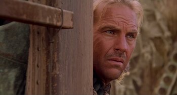 Movie still from “Waterworld” (1995), directed by Kevin Reynolds – A person with long hair and a goatee; Close Up shot, Low angle