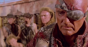 Movie still from “Waterworld” (1995), directed by Kevin Reynolds – A group of men in costume standing next to each other; Close Up shot, Over the shoulder angle