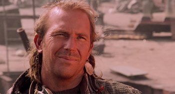 Movie still from “Waterworld” (1995), directed by Kevin Reynolds – A person with long blonde hair; Close Up shot, Low angle