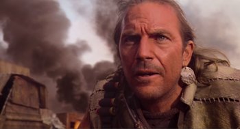 Movie still from “Waterworld” (1995), directed by Kevin Reynolds – A person with smoke in the background; Close Up shot, Low angle