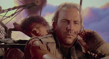 Movie still from “Waterworld” (1995), directed by Kevin Reynolds – A person holding an umbrella; Close Up shot, Low angle
