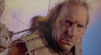Movie still from “Waterworld” (1995), directed by Kevin Reynolds – A man's face in a woolen sweater; Close Up shot, Low angle