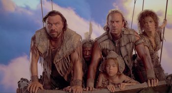 Movie still from “Waterworld” (1995), directed by Kevin Reynolds – A group of people standing next to each other on top of a building; Medium shot, Low angle