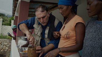 Movie still from “We Feed People” (2022), directed by Ron Howard – A man and a woman working together on a piece of wood; Medium shot, Over the shoulder angle