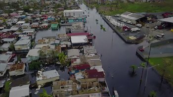 Movie still from “We Feed People” (2022), directed by Ron Howard – An aerial view of a flooded area of a city; Extreme Wide shot, Overhead angle