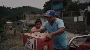 Movie still from “We Feed People” (2022), directed by Ron Howard – A man and a girl unloading boxes from a truck; Medium shot, Low angle