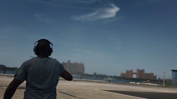 Movie still from “We Feed People” (2022), directed by Ron Howard – A man flying a kite on a cloudy day in a parking lot; Extreme Wide shot, Low angle