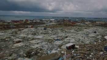 Movie still from “We Feed People” (2022), directed by Ron Howard – A large amount of trash is scattered on the ground; Extreme Wide shot, High angle