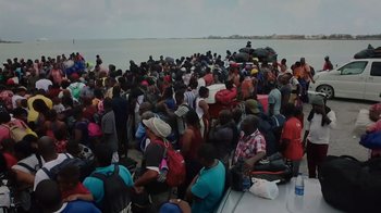 Movie still from “We Feed People” (2022), directed by Ron Howard – A large group of people are gathered on a boat; Extreme Wide shot, High angle