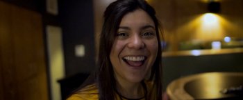 Movie still from “WeWork: Or the Making and Breaking of a $47 Billion Unicorn” (2021), directed by Jed Rothstein – A person with a smile on their face; Close Up shot, Low angle
