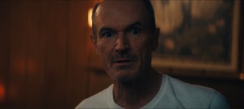 Movie still from “Weird: The Al Yankovic Story” (2022), directed by Eric Appel – An older man with a goatee looking at the camera; Close Up shot, Low angle