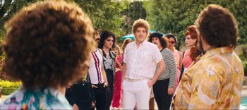 Movie still from “Weird: The Al Yankovic Story” (2022), directed by Eric Appel – A group of people standing in a line wearing white; Wide shot, Over the shoulder angle