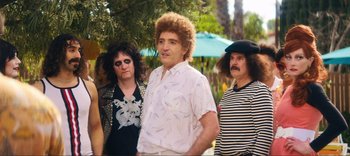 Movie still from “Weird: The Al Yankovic Story” (2022), directed by Eric Appel – A group of men standing next to each other; Medium shot, Over the shoulder angle