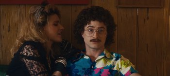 Movie still from “Weird: The Al Yankovic Story” (2022), directed by Eric Appel – A man in a floral shirt and a woman in a floral shirt; Close Up shot, Over the shoulder angle