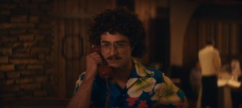 Movie still from “Weird: The Al Yankovic Story” (2022), directed by Eric Appel – A man in a hawaiian shirt talking on a phone; Close Up shot, High angle