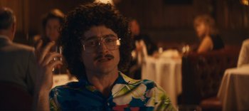 Movie still from “Weird: The Al Yankovic Story” (2022), directed by Eric Appel – A man in a hawaiian shirt and glasses looks to his left; Close Up shot, Over the shoulder angle