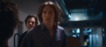 Movie still from “Weird: The Al Yankovic Story” (2022), directed by Eric Appel – A man with long blonde hair standing next to another man; Close Up shot, Over the shoulder angle