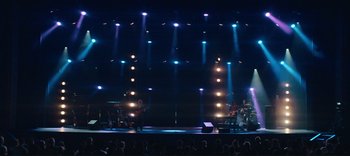 Movie still from “Weird: The Al Yankovic Story” (2022), directed by Eric Appel – A band performing on a stage at a concert; Extreme Wide shot, Low angle