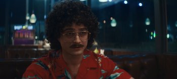 Movie still from “Weird: The Al Yankovic Story” (2022), directed by Eric Appel – A man in a red shirt with a mustache; Close Up shot, Over the shoulder angle