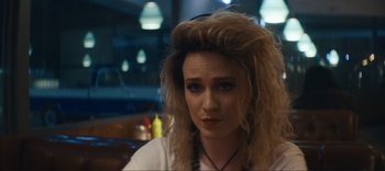 Movie still from “Weird: The Al Yankovic Story” (2022), directed by Eric Appel – A person wearing headphones near a table; Close Up shot, Over the shoulder angle