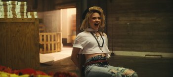 Movie still from “Weird: The Al Yankovic Story” (2022), directed by Eric Appel – A woman in a white shirt is laughing; Medium shot, Low angle