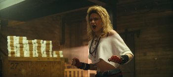 Movie still from “Weird: The Al Yankovic Story” (2022), directed by Eric Appel – A woman with blonde curly hair wearing a white top; Medium shot, Low angle