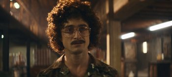 Movie still from “Weird: The Al Yankovic Story” (2022), directed by Eric Appel – A man with a mustache and curly brown hair; Close Up shot, Over the shoulder angle