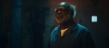 Movie still from “Weird: The Al Yankovic Story” (2022), directed by Eric Appel – An older man with a gray beard is looking up; Close Up shot, Low angle