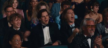 Movie still from “Weird: The Al Yankovic Story” (2022), directed by Eric Appel – A group of people sitting in front of each other; Medium shot, Low angle