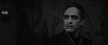 Movie still from “Werewolf by Night” (2022), directed by Michael Giacchino – A black and white photo of a man in a black suit; Close Up shot, Over the shoulder angle