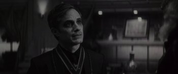 Movie still from “Werewolf by Night” (2022), directed by Michael Giacchino – Black and white photograph of a man in a suit; Close Up shot, Over the shoulder angle