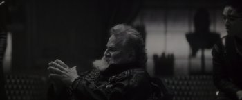 Movie still from “Werewolf by Night” (2022), directed by Michael Giacchino – An old man with a beard is sitting in a room; Close Up shot, Low angle