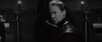 Movie still from “Werewolf by Night” (2022), directed by Michael Giacchino – An older woman wearing a black leather jacket; Close Up shot, Over the shoulder angle