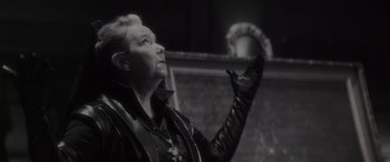 Movie still from “Werewolf by Night” (2022), directed by Michael Giacchino – A woman in a black leather jacket and black leather gloves; Close Up shot, Low angle