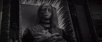 Movie still from “Werewolf by Night” (2022), directed by Michael Giacchino – A black and white photo of a man with makeup on; Close Up shot, High angle