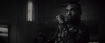 Movie still from “Werewolf by Night” (2022), directed by Michael Giacchino – A black and white photo of a man sitting in front of a window; Close Up shot, Low angle