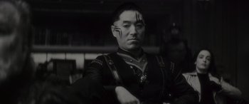 Movie still from “Werewolf by Night” (2022), directed by Michael Giacchino – A black and white photo of a man with a face tattoo; Close Up shot, Low angle