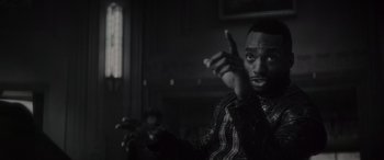 Movie still from “Werewolf by Night” (2022), directed by Michael Giacchino – A black and white photo of a man pointing at the camera; Close Up shot, Over the shoulder angle