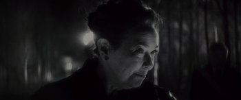 Movie still from “Werewolf by Night” (2022), directed by Michael Giacchino – An older woman is looking into the distance; Close Up shot, Over the shoulder angle