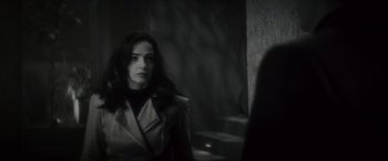 Movie still from “Werewolf by Night” (2022), directed by Michael Giacchino – A black and white photo of a woman looking at the camera; Medium shot, Over the shoulder angle