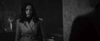 Movie still from “Werewolf by Night” (2022), directed by Michael Giacchino – A black and white photo of a woman in a leather jacket; Medium shot, Over the shoulder angle