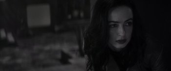 Movie still from “Werewolf by Night” (2022), directed by Michael Giacchino – A person with long dark hair; Close Up shot, Over the shoulder angle