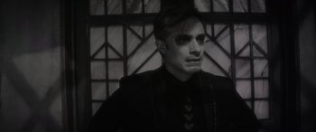 Movie still from “Werewolf by Night” (2022), directed by Michael Giacchino – A black and white photo of a man in a black shirt; Close Up shot, Over the shoulder angle