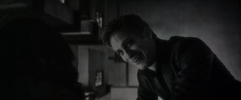 Movie still from “Werewolf by Night” (2022), directed by Michael Giacchino – A black and white photo of a man smiling; Close Up shot, Over the shoulder angle