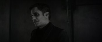 Movie still from “Werewolf by Night” (2022), directed by Michael Giacchino – A black and white photo of a man with a creepy look on his face; Close Up shot, Over the shoulder angle