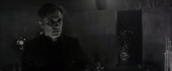 Movie still from “Werewolf by Night” (2022), directed by Michael Giacchino – A black and white photo of a man looking at the camera; Close Up shot, Over the shoulder angle