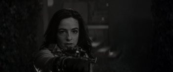 Movie still from “Werewolf by Night” (2022), directed by Michael Giacchino – A black - and - white photo of a woman holding a gun; Close Up shot, Over the shoulder angle