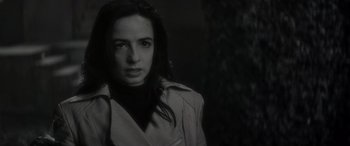Movie still from “Werewolf by Night” (2022), directed by Michael Giacchino – A black and white photo of a woman in a trench coat; Close Up shot, Over the shoulder angle
